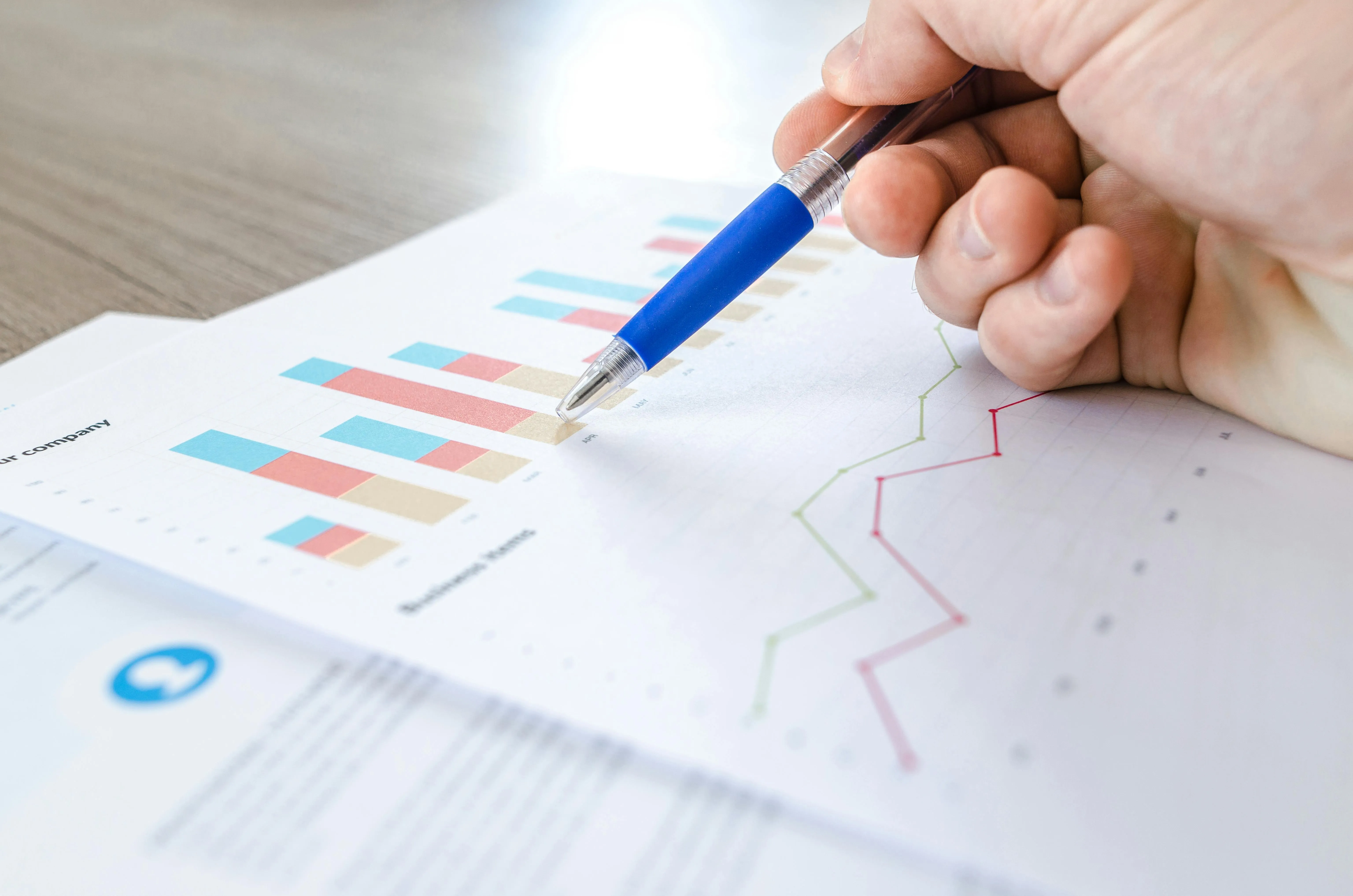 Pen pointing to financial graphs
